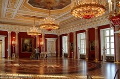 an ornate room with chandeliers and paintings on the walls