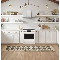 a kitchen with white cabinets and an oven in the center, along with a rug on the floor