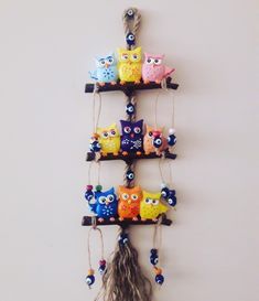 an assortment of colorful owls hanging on a wall