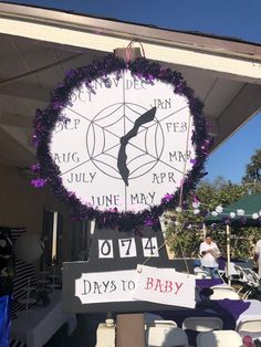 a large white clock with purple flowers around it