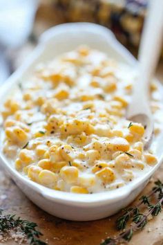 a white bowl filled with macaroni and cheese on top of a cutting board