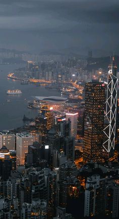 an aerial view of a city at night with the lights on and buildings lit up