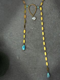 Capture the impactful symbology of natural gemstones with this artisan sequin bolo necklace. Adorned with a single natural keshi pearl, genuine Arizona Sleeping Beauty turquoise, micro faceted amazonite round & a hammered teardrop, this intentional necklace reflects the symbolism found throughout life's journey. Embrace the essence of the Desert & the Sea with peace of mind knowing this necklace was handcrafted in the USA with ethically sourced gemstones that tell a unique story. Baroque Keshi Pearl Sequin Chain Bolo Necklace Ft. Genuine Arizona Sleeping Beauty Turquoise (Necklace Only): ✿ Raw USA brass, natural baroque freshwater keshi pearl, genuine Arizona Sleeping Beauty turquoise, micro faceted Peruvian amazonite Please note - Items are made with raw bronze, copper & brass which may o Artisan Gold Jewelry With Pearl Charm, Fusion Gold Jewelry With Natural Stones, Gold Fusion Jewelry With Natural Stones, Bohemian Baroque Pearl Jewelry As Gift, Bohemian Baroque Pearl Jewelry For Gift, Bohemian Baroque Pearl Jewelry Gift, Turquoise Necklace With Pearl Drop As Gift, Turquoise Necklace With Pearl Drop For Gift, Adjustable Bohemian Pearl Drop Jewelry