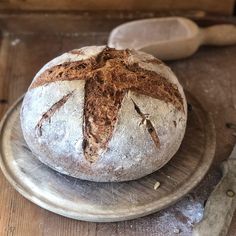 a loaf of bread sitting on top of a metal plate next to a pair of scissors