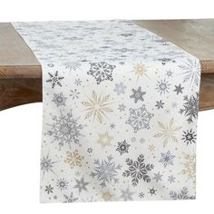 a white table with silver and gold snowflakes on the tablecloth, next to a wooden bench