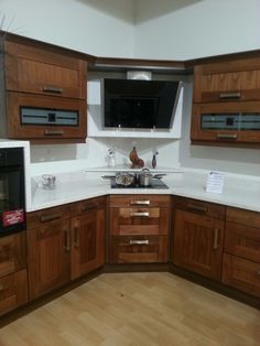 a kitchen with wooden cabinets and white counter tops, has a microwave on the wall