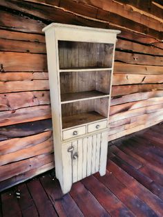 an old white cabinet with wooden floors and walls