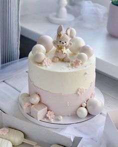 a white cake with pink frosting and decorations