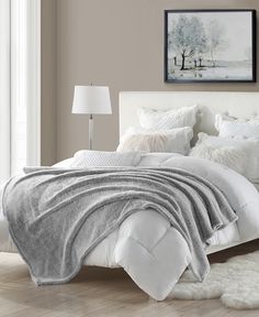 a bed with white sheets and pillows in a bedroom