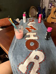 a denim table cloth with letters and numbers painted on it, along with paintbrushes