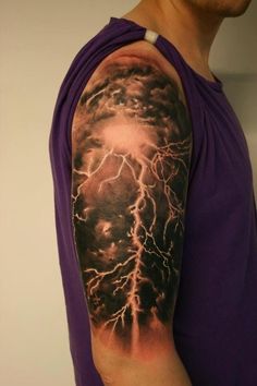 a man wearing a purple shirt has a lightning tattoo on his arm and shoulder,