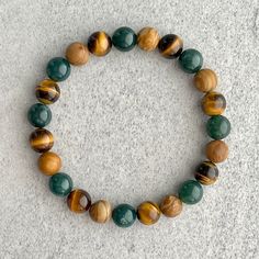 ~ 8mm moss agate beads ~ 8mm yellow tiger eye beads ~ 8mm wood jasper beads ~ Stretchy cord; simply slide bracelet on and off wrist ~ Comes packaged in a re-usable microfibre pouch To ensure the perfect fit, please use the bracelet sizing instructions found in the photo gallery. Cheap Wooden Beads Bracelet, Cheap Wooden Bead Bracelets For Gifts, Cheap Agate Beaded Bracelets, Yellow Beaded Bracelets, Jasper Bead Bracelet, Stretchy Beaded Bracelet, Slide Bracelet, Jasper Bracelet, Beads Bracelet Design