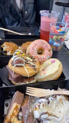 three boxes filled with different types of doughnuts and pastries on top of a table