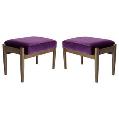 a pair of stools with purple velvet upholstered seats on each side and wooden legs