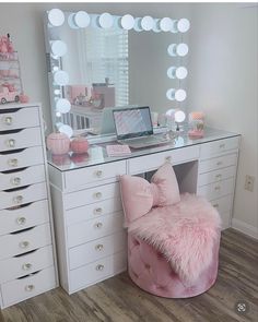 a pink chair sitting in front of a desk with a laptop