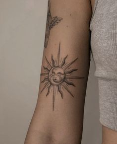 a woman with a sun tattoo on her arm