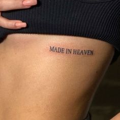 a woman's stomach with the words made in heaven tattooed on her lower back