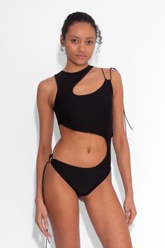 The elongated silhouette of this one piece contributes to a dramatic and visually striking effect, gracefully accentuating the contours of the body. The stretch capability of the fabric further adds to the comfort factor, allowing for easy mobility without compromising on style. Suitable for swim and party wear, with self lining for a thick, durable fit.  Flattering cut out details  Adjustable shoulder toggle Double layer with lining  Stretch lycra fabric   Length: 67cm The model is 5ft 9 and we Modern Black Fitted Bodysuit, Modern Fitted Black Bodysuit, Black Bodysuit For Party, Modern Black Stretch Bodysuit, Fitted Black Modern Bodysuit, Summer Cutout Bodysuit In Elastane, Stretch Cutout One-piece For The Beach, Asymmetrical Black Stretch Bodysuit, One-piece Cutout Bodysuit For Swimming