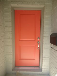 an orange front door is shown in this photo