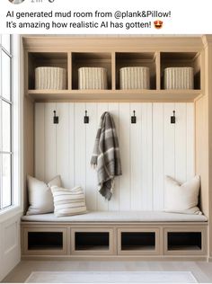 a white bench with pillows and blankets on it next to a wall mounted coat rack