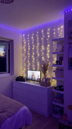 a bedroom with purple lights on the wall and a television in the middle of the room