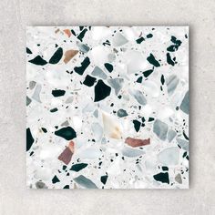 a white tile with black and brown pebbles on it