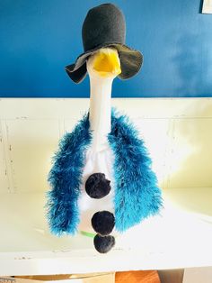 a blue and white stuffed animal with a hat on it's head hanging from a hook