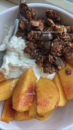 a white plate topped with granola and peaches next to yogurt sauce