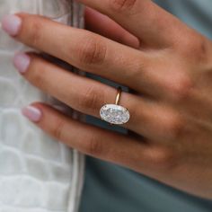 a woman's hand with a diamond ring on it