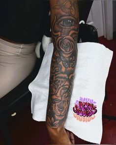 a man's arm with tattoos on it and a white towel in front of him