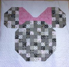 a quilted mickey mouse head with a pink bow