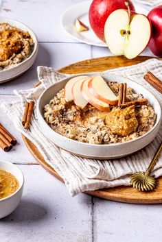 an oatmeal dish with apples and cinnamon sticks