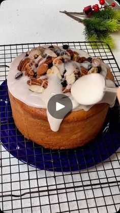 a cake with icing and nuts is on a cooling rack