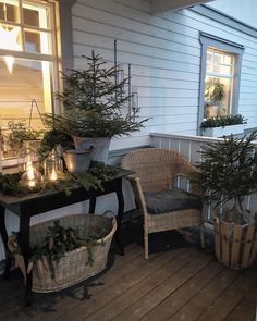 two wicker chairs sitting on top of a wooden deck next to potted plants