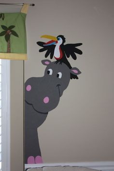 a child's room with a mural of a toucan on the wall