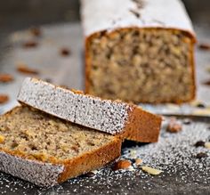 two pieces of bread sitting on top of a table covered in powdered sugar and nuts