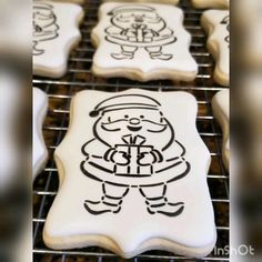 decorated cookies with black and white frosting on cooling racks, including santa's sleigh