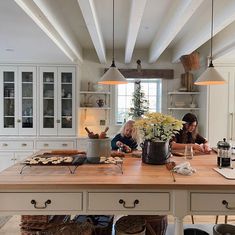 two people sitting at a kitchen island with food on it