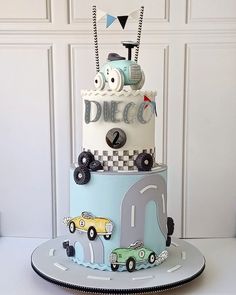 a three tiered cake with cars and trucks on it