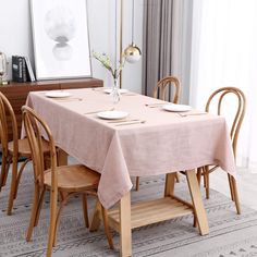 a dining room table is set with plates and cups on it, along with chairs