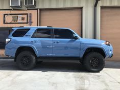 a blue suv parked in front of a garage