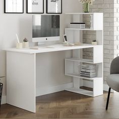 a white desk with a computer on it in front of two pictures and a chair