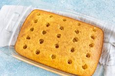 a cake in a glass baking dish on a blue surface