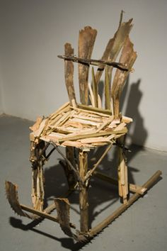 a wooden chair made out of sticks and wood with no legs, sitting on the floor