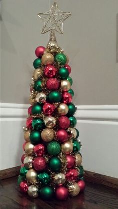 a small christmas tree with ornaments on it's sides and a star hanging from the top