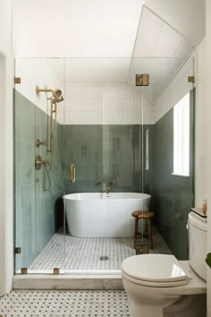 a white bath tub sitting inside of a bathroom next to a toilet and shower head