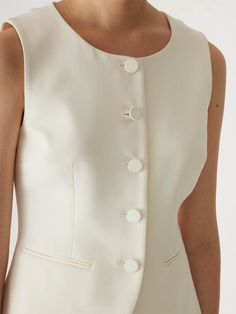 Featuring a sleek, tailored design and elegant button detailing, this vest is perfect for layering over blouses or dresses. Ideal for both professional and casual settings, it adds a polished touch to any outfit. The fabric is made in Turkey. Elegant button detailing Perfect for layering Fabric made in Turkey 41% Wool, 52% Polyester, 4% Elastane, 3% Polyamide Dry Clean Only Tailored Button-up Vest For Workwear, Tailored Vest With Button Closure For Workwear, Tailored Buttoned Vest For Workwear, Tailored Workwear Vest With Buttons, Elegant Fitted Tops With Covered Buttons, Tailored Elegant Vest With Button Closure, Elegant Tailored Vest With Button Closure, Fitted Button Closure Office Vest, Fitted Office Vest With Button Closure