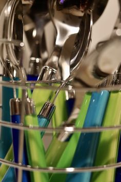 a metal container filled with green and blue utensils