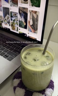 a drink sitting in front of a laptop computer