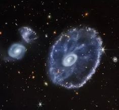 two blue spiral shaped objects in the middle of a black sky with stars around them